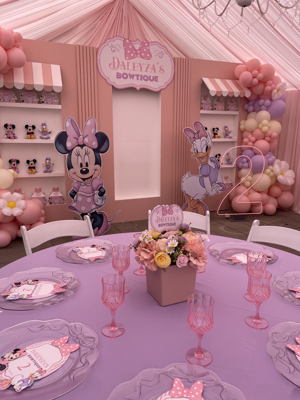 Minnie Mouse themed 'Daleyza's Bowtique' birthday with pink and lavender décor, character cutouts, balloon garland and themed place settings